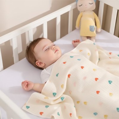 couverture bébé mousseline couleur crème motif coeurs enfant endormi