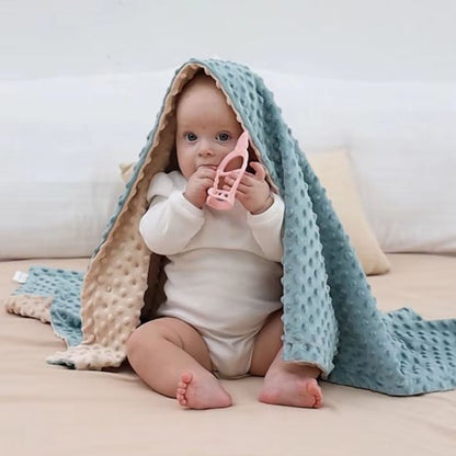 couverture bébé réversible texturée beige bleue enfant assis objet mains