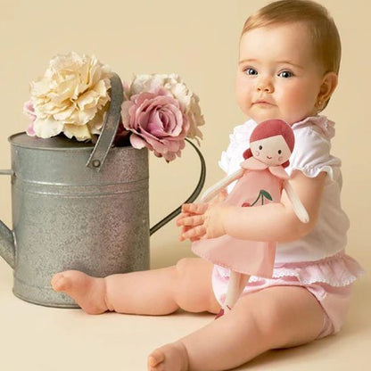 doudou bébé ballerine fille enfant poupée dans les mains assis sol fleurs pot