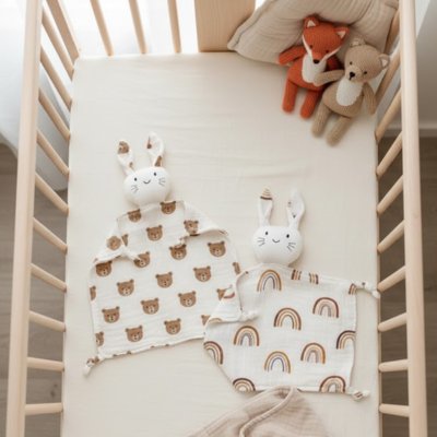 doudou bébé lapin câlin deux variantes arc-en-ciel et ourson dans berceau