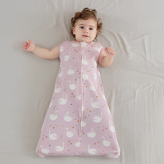 gigoteuse rose motifs cygnes blancs coeurs enfant couché pleine grandeur