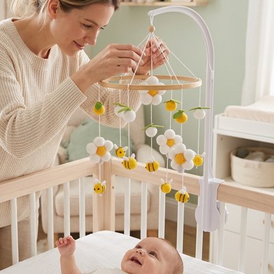 mobile bébé en bois en laine abeilles fleurs jaunes gros plan maman