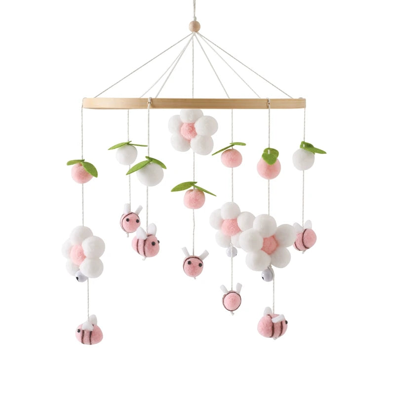 mobile bébé en bois en laine abeilles fleurs roses gros plan fond blan