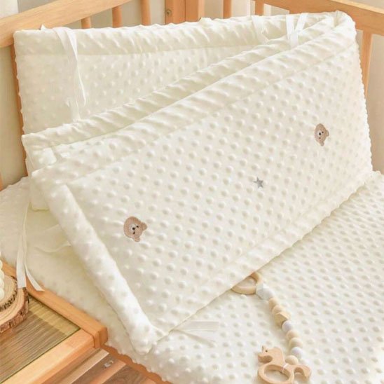 tour de lit bébé tissu avec texture ourson fond blanc gros plan plié