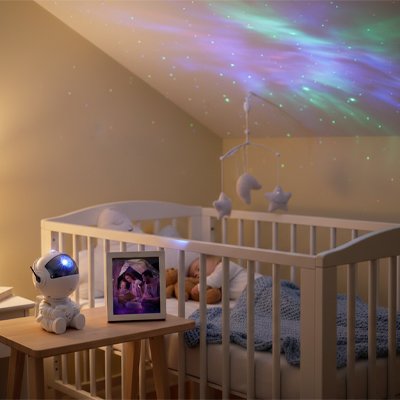 veilleuse bébé projection astronaute sur table chevet berceau enfant endormi couverture bleue